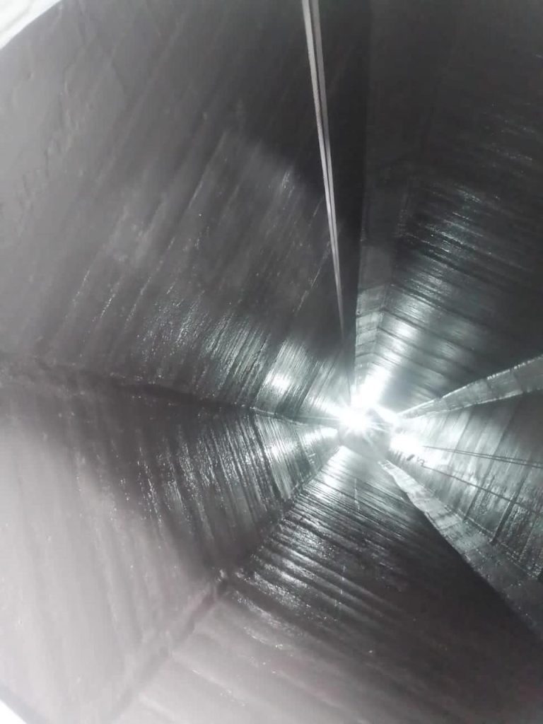 View of the inside of an industrial bin, showing surface condition and structural features for inspection or maintenance