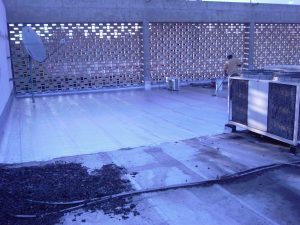 Silver waterproofing material applied to the surface of a different roof, enhancing protection and heat reflection