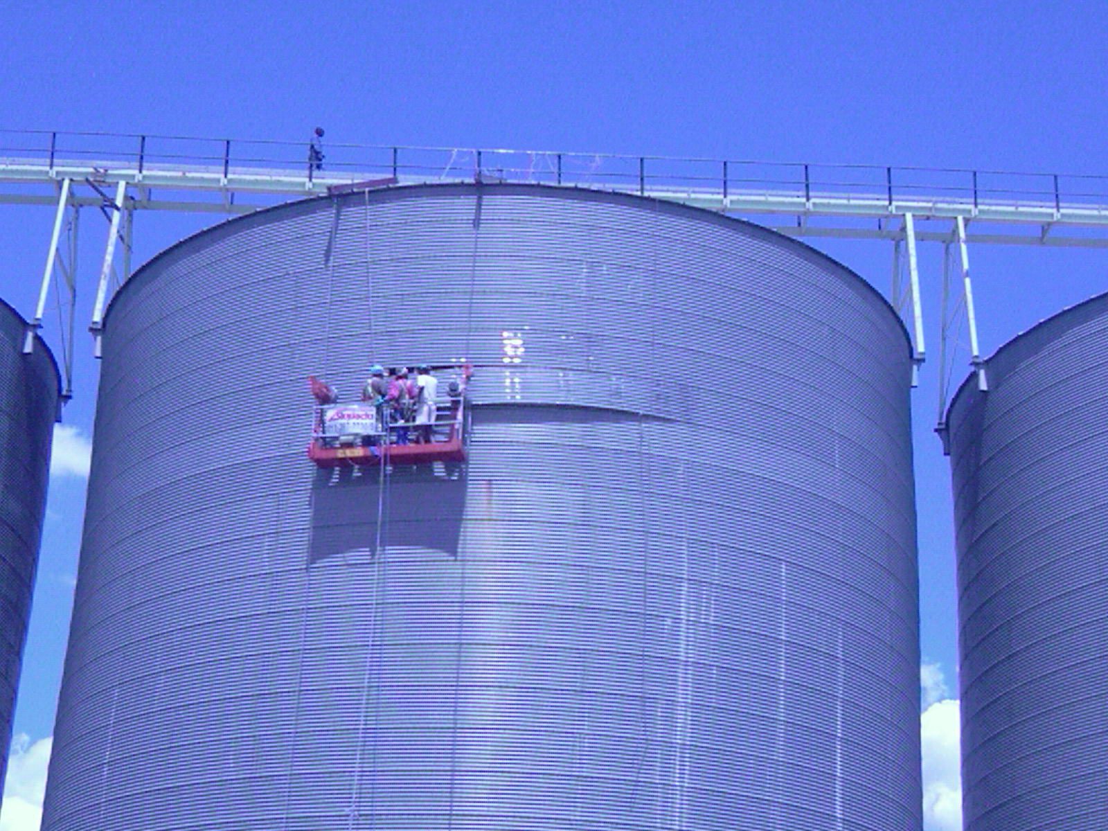 Construction team replacing corroded or damaged steel sections on a silo to restore structural integrity