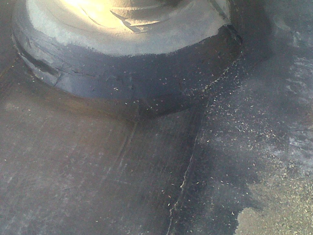 Close-up of bitumen waterproofing layer being applied on roof surface to provide durable water protection